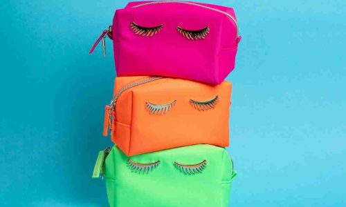 A stack of three colorful bags with eyelashes on them